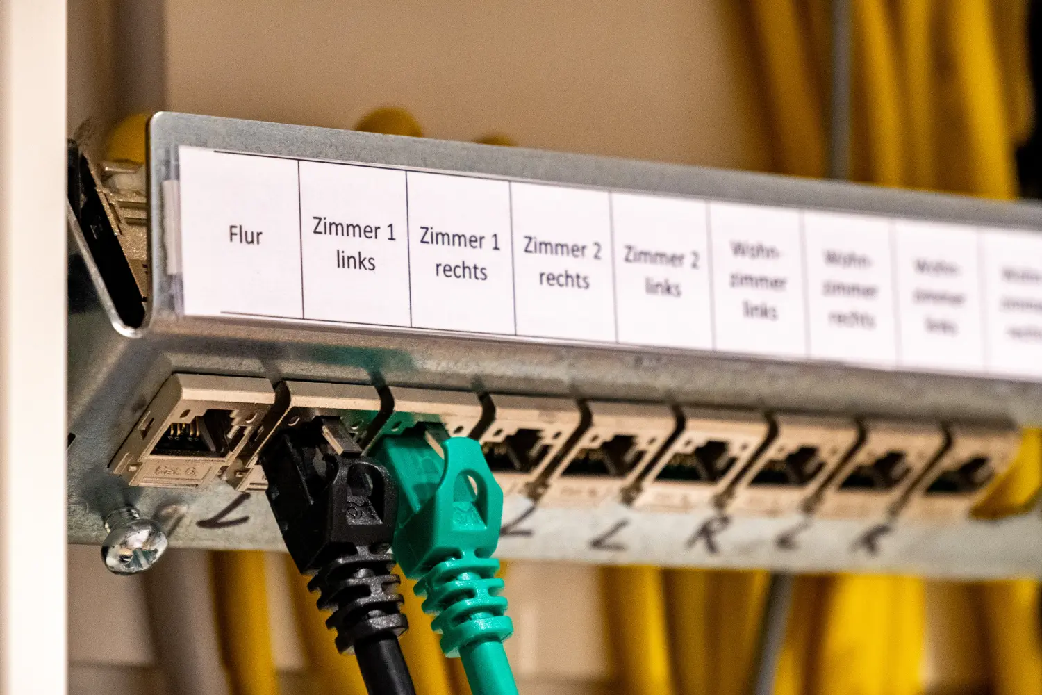 Ethernet-Netzwerkanschlüsse oder -Ports in einem Schaltschrank zur Verteilung in einer Wohnung, beschriftet in deutscher Sprache